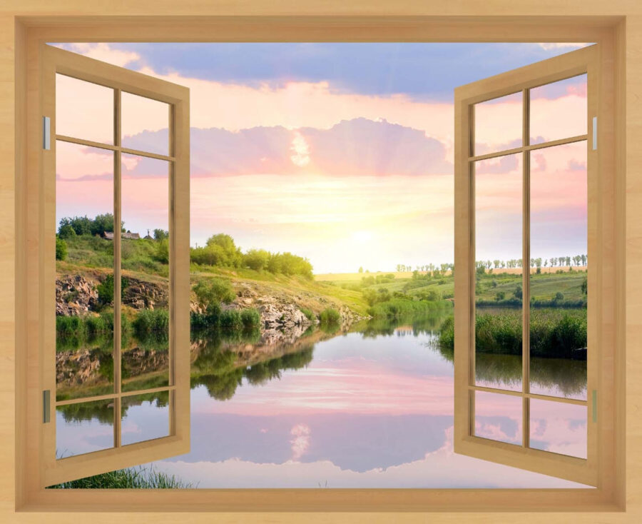 Window with a view of a river and a grassy hill