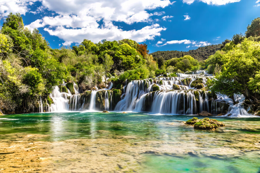 Krka National Park surrounded by trees and a blue sky