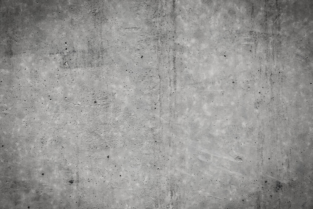 Grey concrete wall with black spots Grey concrete wall with black spots