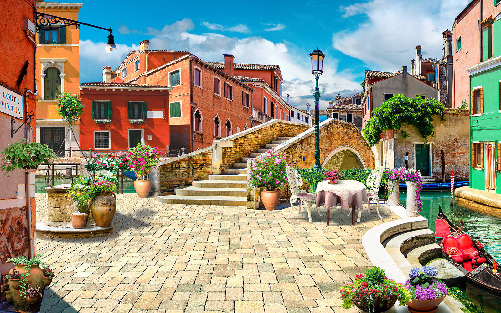 u18551p - Patio with a table and chairs and a fountain in front of a building - tegory