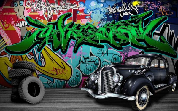 Black car with wheels in front of a colorful wall Black car with wheels in front of a colorful wall