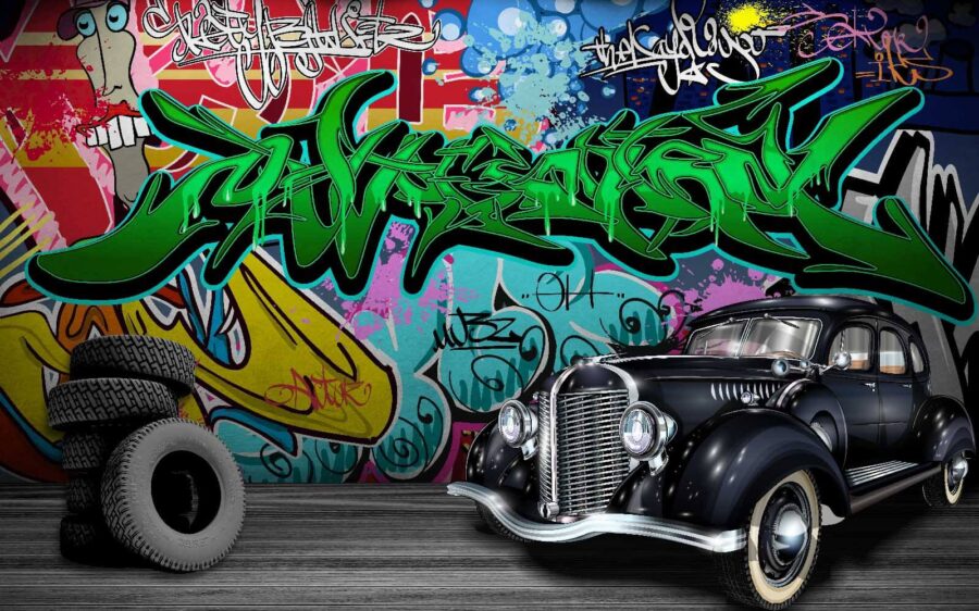 Black car with wheels in front of a colorful wall Black car with wheels in front of a colorful wall