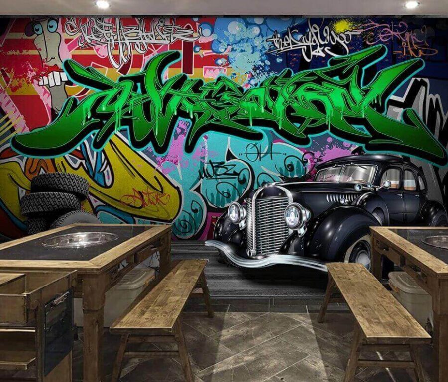 Black car with wheels in front of a colorful wall Black car with wheels in front of a colorful wall
