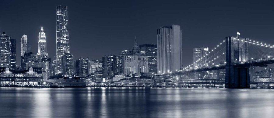 City skyline at night with a bridge over water