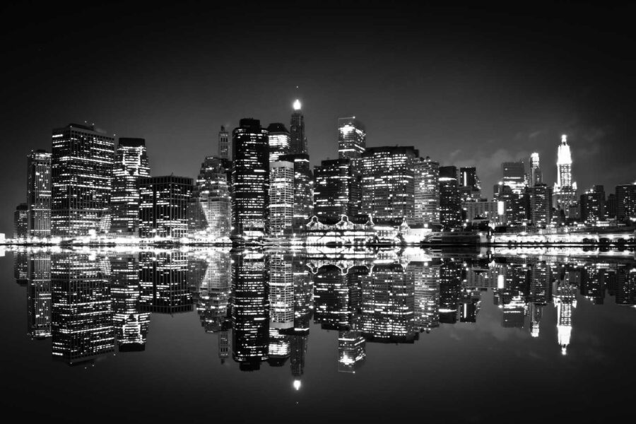 City skyline at night with lights reflecting on water