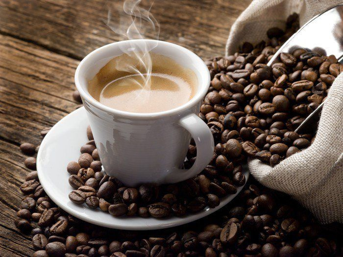 Cup of coffee on a saucer with coffee beans Cup of coffee on a saucer with coffee beans