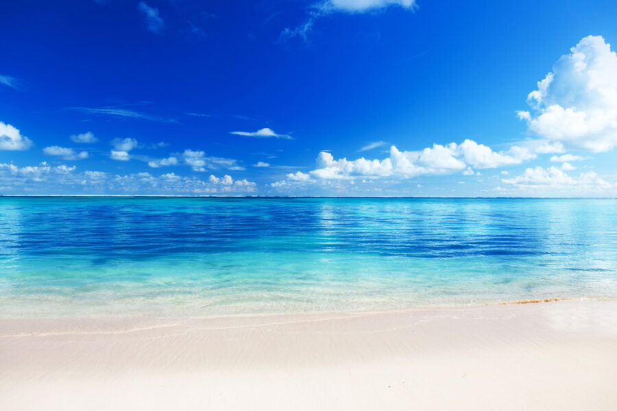 Beach with blue water and clouds