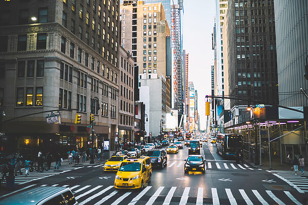 A city street with many buildings and cars A city street with many buildings and cars