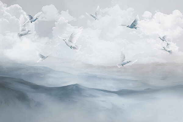 Group of white birds flying over a mountain