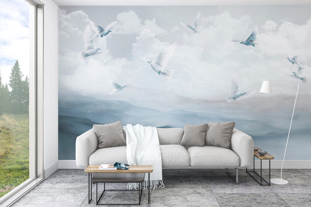 Group of white birds flying over a mountain