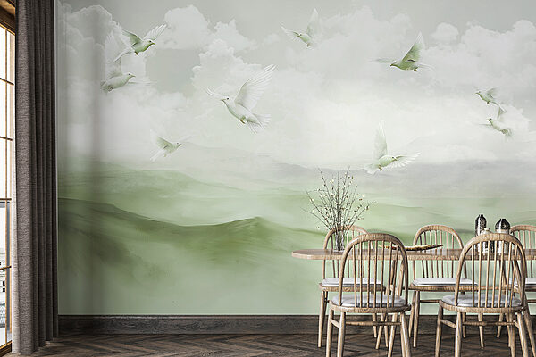 Group of white birds flying over a foggy landscape