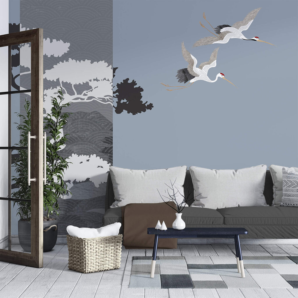 Couple of cranes flying next to a tree